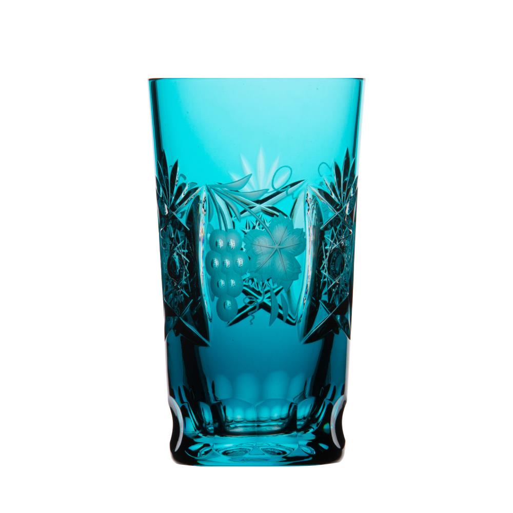 Tall, cylindrical long drink glass crafted from blue-turquoise crystal glass, intricately cut. Star and diagonal patterns wind their way around the glass. Grape motif with leaves and tendrils. Faceted, sturdy base.
